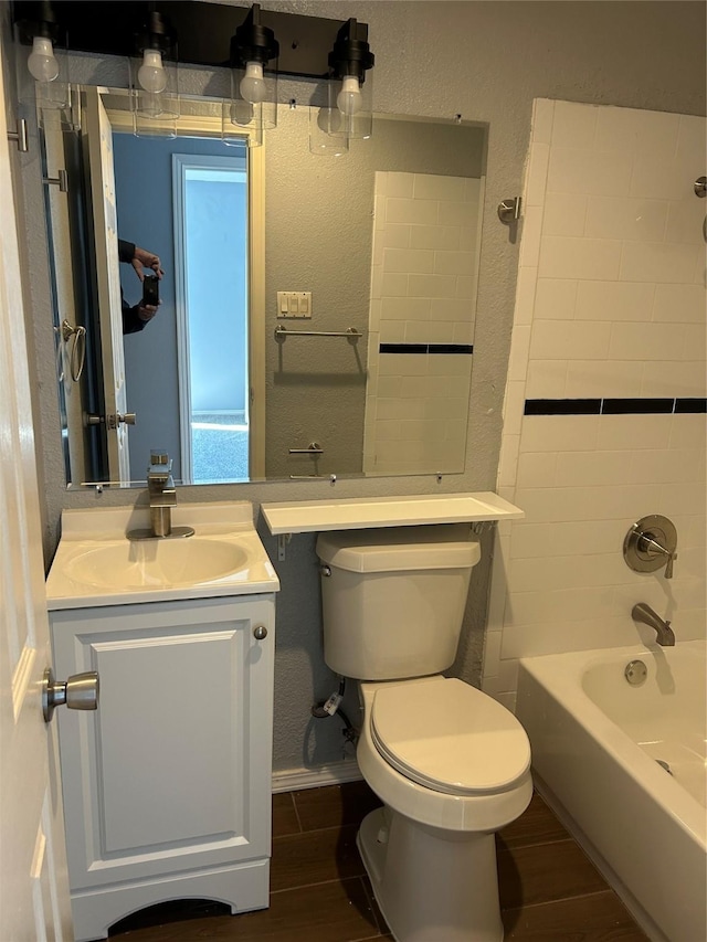 full bathroom with vanity, tiled shower / bath combo, and toilet