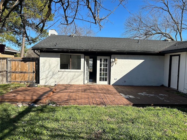 back of property featuring a lawn and a deck