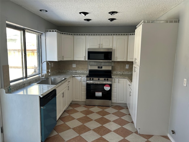 kitchen featuring decorative backsplash, white cabinetry, sink, and stainless steel appliances