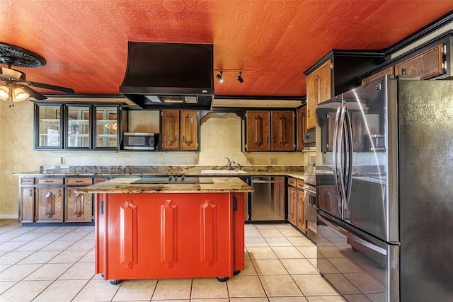 kitchen featuring stainless steel appliances, ventilation hood, light tile patterned floors, a kitchen island, and sink