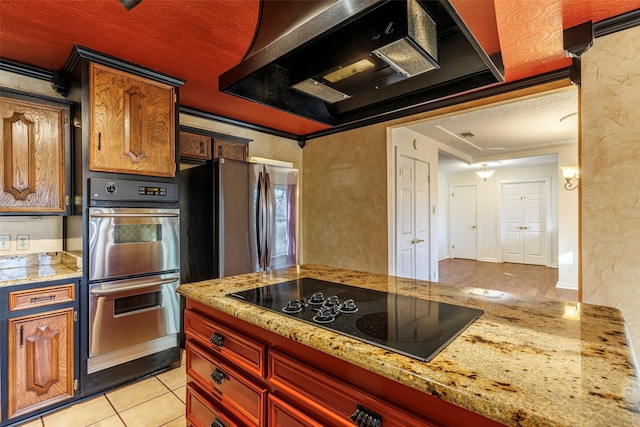 kitchen featuring stainless steel appliances, light tile patterned flooring, light stone countertops, range hood, and crown molding