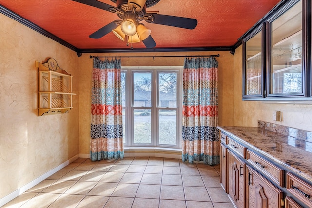 interior space featuring ceiling fan, crown molding, and light tile patterned floors