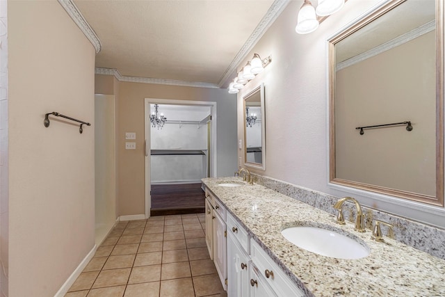 bathroom with tile patterned flooring, ornamental molding, and vanity