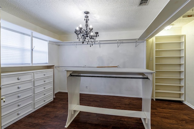 walk in closet featuring an inviting chandelier and dark hardwood / wood-style flooring