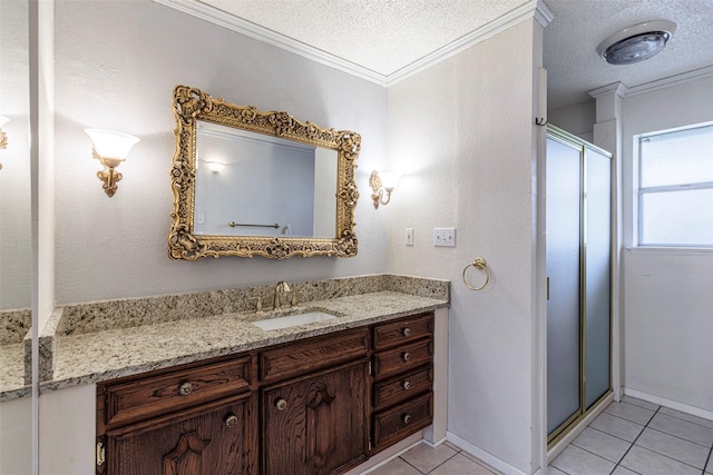 bathroom with a textured ceiling, tile patterned flooring, an enclosed shower, ornamental molding, and vanity