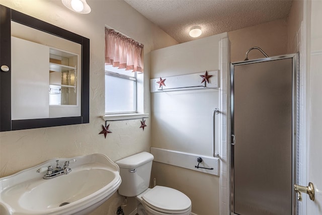 bathroom featuring sink, toilet, a textured ceiling, and a shower with shower door