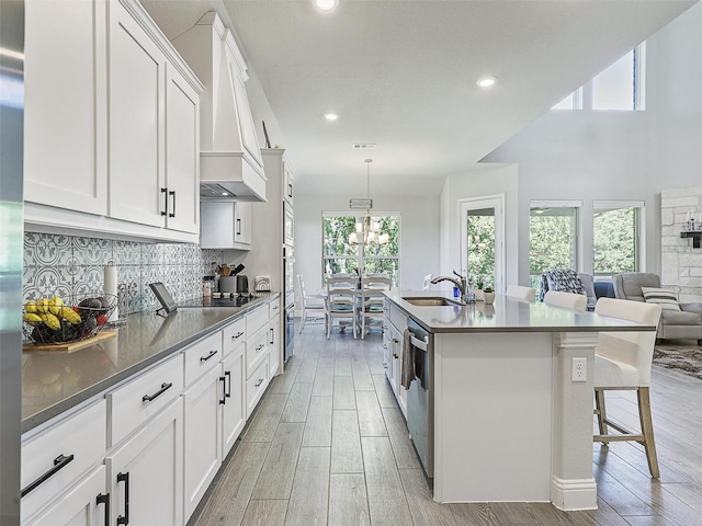 kitchen with a center island with sink, white cabinetry, stainless steel appliances, and sink