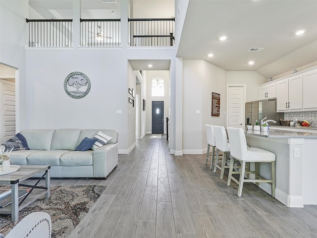 living room with high vaulted ceiling and light hardwood / wood-style floors