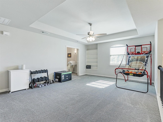 interior space with carpet, a textured ceiling, a raised ceiling, and ceiling fan