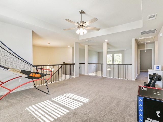 rec room with carpet flooring, ceiling fan, and a tray ceiling