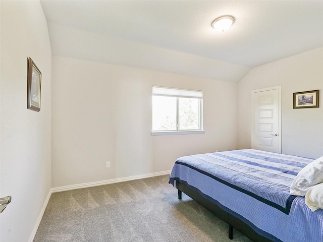 carpeted bedroom with lofted ceiling