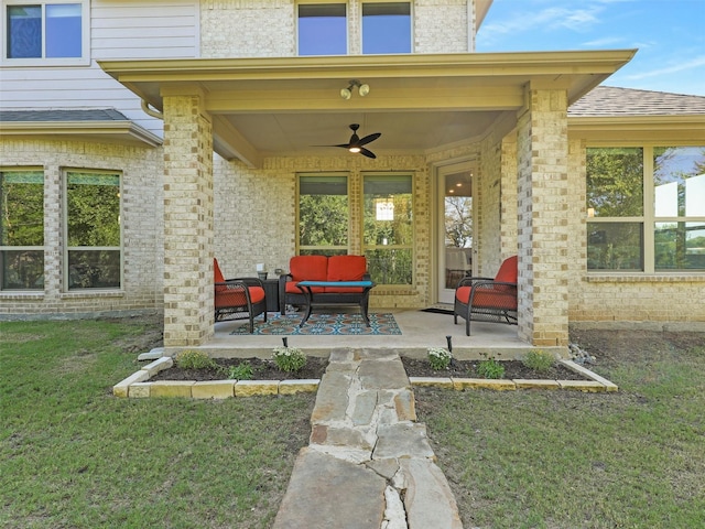 doorway to property featuring outdoor lounge area, ceiling fan, a yard, and a patio area