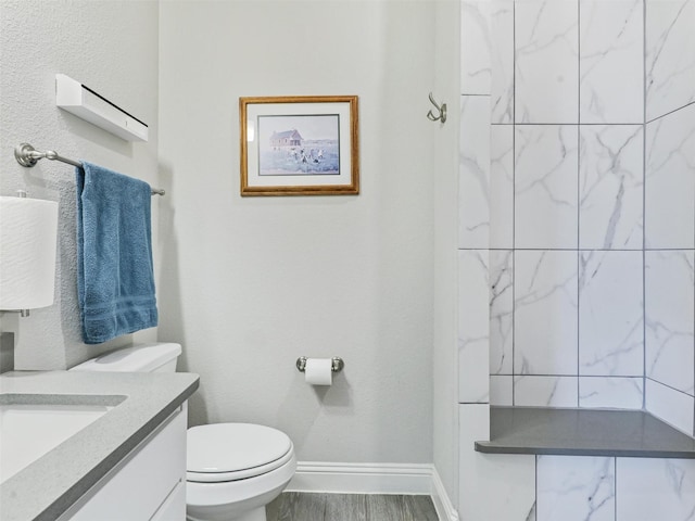 bathroom with hardwood / wood-style flooring, vanity, and toilet