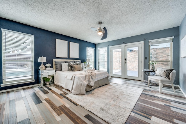 bedroom with french doors, hardwood / wood-style flooring, ceiling fan, access to exterior, and a textured ceiling