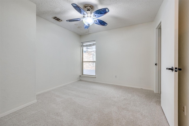 carpeted empty room featuring ceiling fan and a textured ceiling