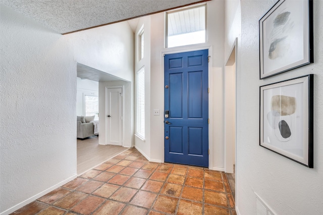 entryway with a high ceiling and a textured ceiling