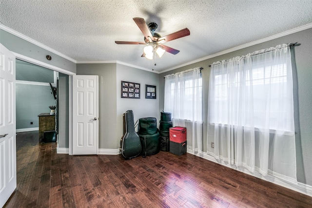 living area with a textured ceiling, ceiling fan, ornamental molding, and dark wood-type flooring