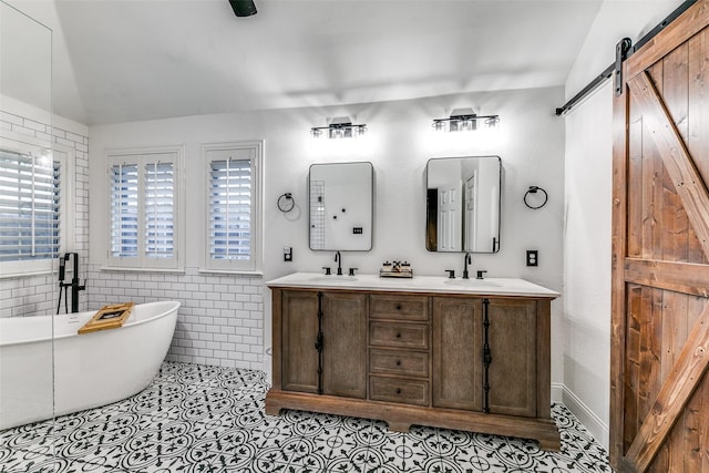 bathroom with a washtub, vaulted ceiling, plenty of natural light, and tile walls