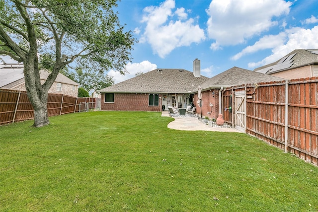 back of house with a patio area and a lawn