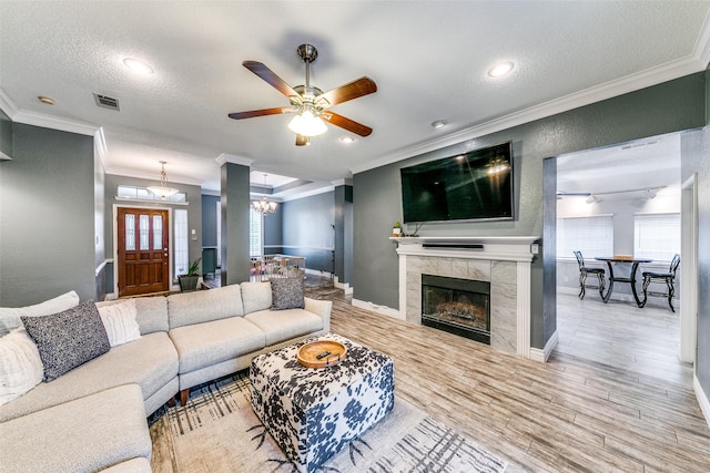 living room with a healthy amount of sunlight, ornamental molding, and a textured ceiling