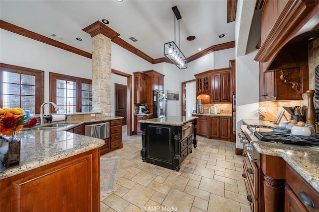 kitchen with decorative backsplash, a kitchen island, light stone counters, and crown molding