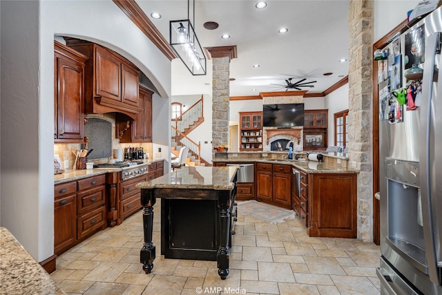 kitchen with a breakfast bar, light stone counters, stainless steel appliances, and decorative light fixtures