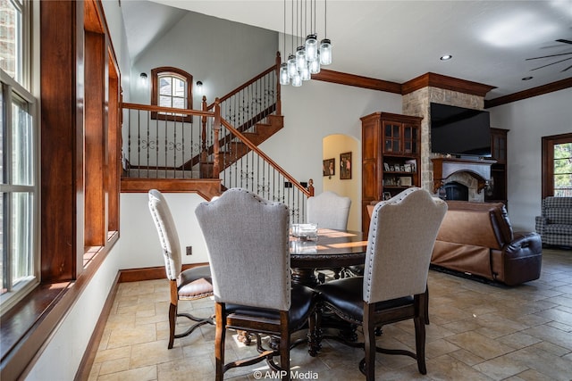 dining area with a fireplace, a chandelier, and ornamental molding