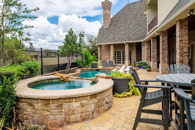 view of patio with a swimming pool with hot tub