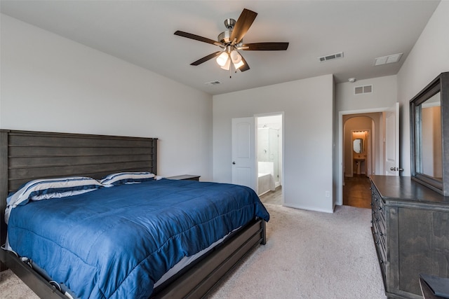 bedroom with connected bathroom, ceiling fan, and light carpet