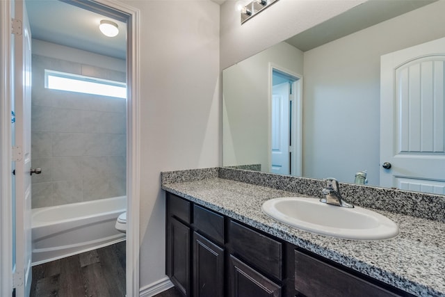 full bathroom featuring wood-type flooring, vanity, toilet, and tub / shower combination