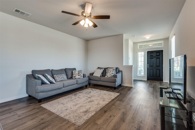 living room with ceiling fan and dark wood-type flooring