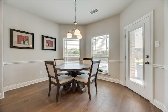 dining area with dark hardwood / wood-style flooring and a chandelier