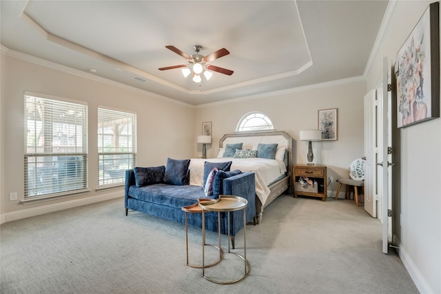 carpeted bedroom featuring ceiling fan, a raised ceiling, and ornamental molding