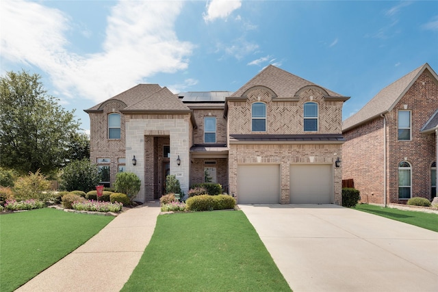 view of front of house featuring solar panels, a front lawn, and a garage