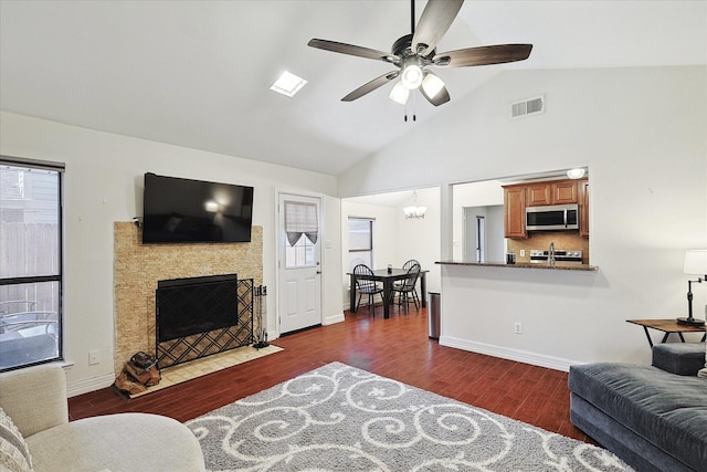 living room featuring dark hardwood / wood-style floors, lofted ceiling, and ceiling fan with notable chandelier