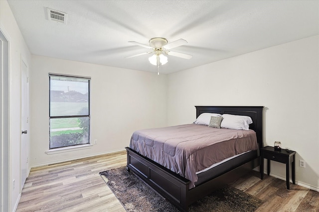 bedroom featuring ceiling fan, a textured ceiling, and light hardwood / wood-style flooring