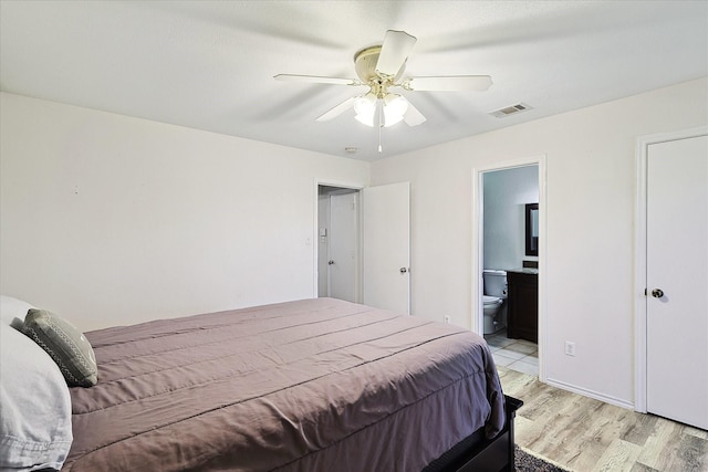 bedroom featuring light wood-type flooring, connected bathroom, and ceiling fan