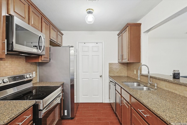 kitchen with sink, dark hardwood / wood-style floors, appliances with stainless steel finishes, tasteful backsplash, and light stone counters