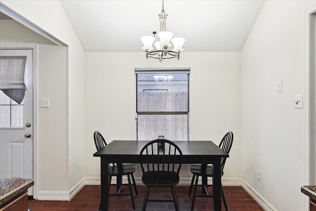 dining area featuring vaulted ceiling, a wealth of natural light, and a chandelier