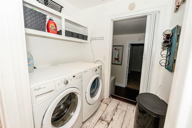 clothes washing area with light hardwood / wood-style floors and washer and clothes dryer