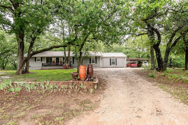 ranch-style home featuring a carport, covered porch, and a front yard