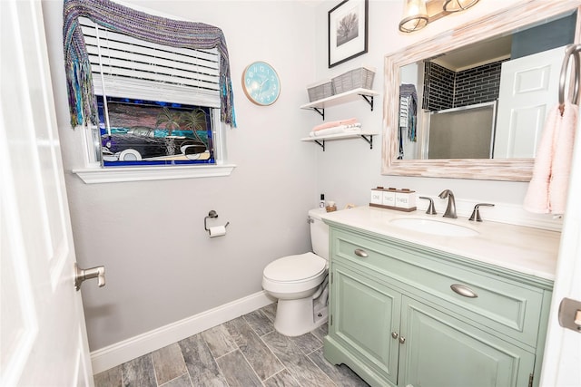 bathroom featuring vanity, toilet, and a shower with shower door