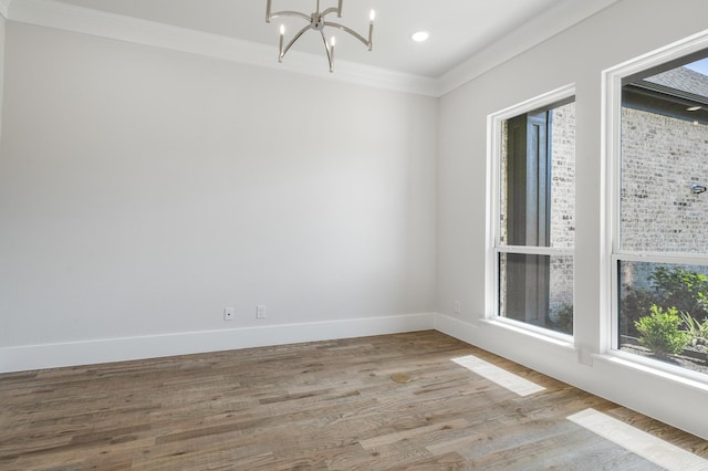 unfurnished room with ornamental molding, light hardwood / wood-style floors, and a notable chandelier