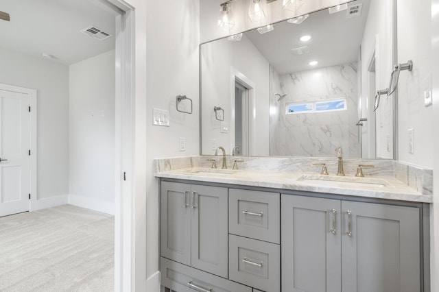 bathroom featuring a tile shower and vanity