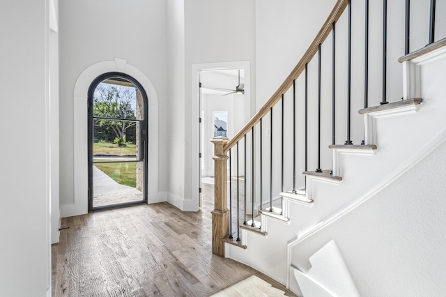 foyer entrance featuring a high ceiling, light hardwood / wood-style floors, and ceiling fan