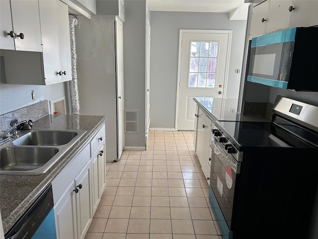 kitchen with dishwashing machine, sink, light tile patterned floors, electric range, and white cabinets