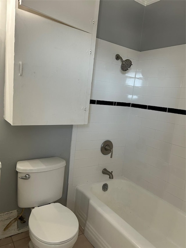 bathroom featuring toilet, tile patterned floors, and tiled shower / bath