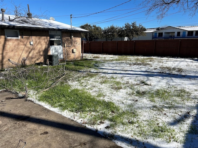 yard layered in snow featuring central AC unit