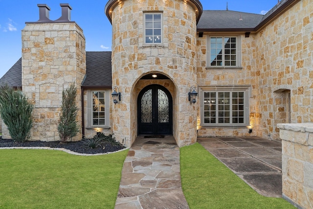 entrance to property featuring a yard and french doors