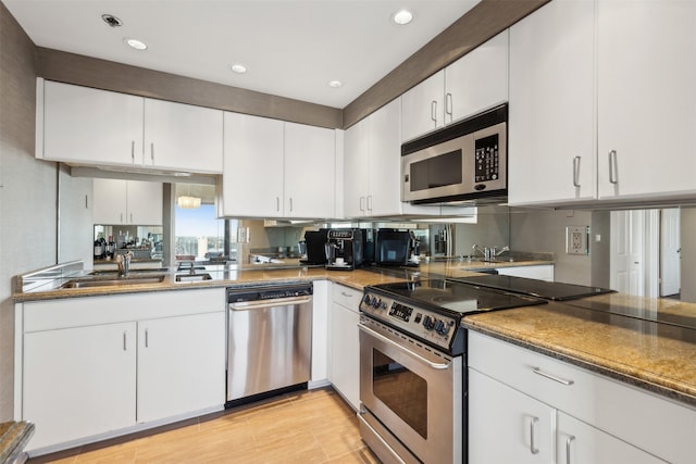 kitchen featuring white cabinets, appliances with stainless steel finishes, tasteful backsplash, and dark stone counters